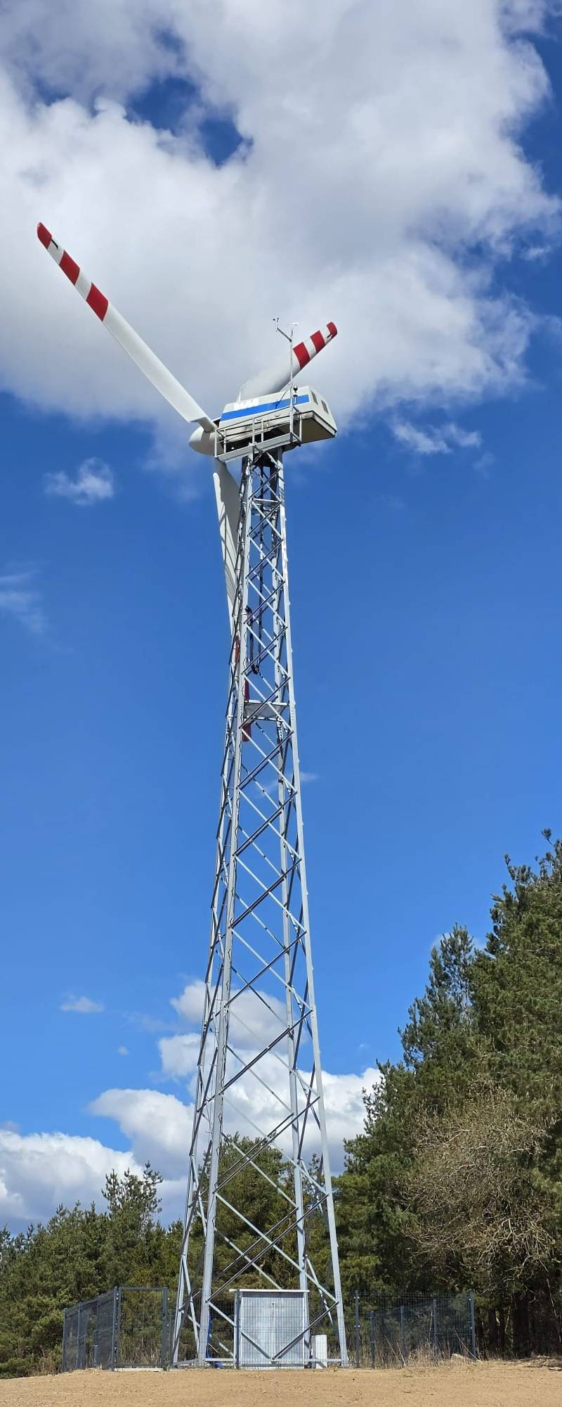 Realizacja FNC Poland - turbina wiatrowa na tle błękitnego nieba i lasu